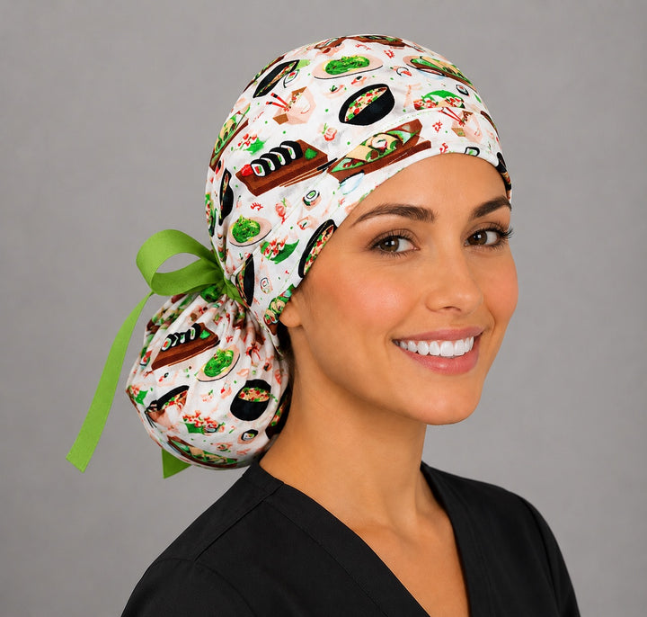 Woman wearing sushi ponytail scrub cap, front view smiling with sushi rolls, edamame and ramen bowls print and lime green ribbon tie