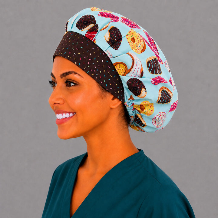 Side view of the sweet pastry bouffant surgical cap — éclairs and glazed donuts with brown sprinkle band, roomy cotton cap for nurses