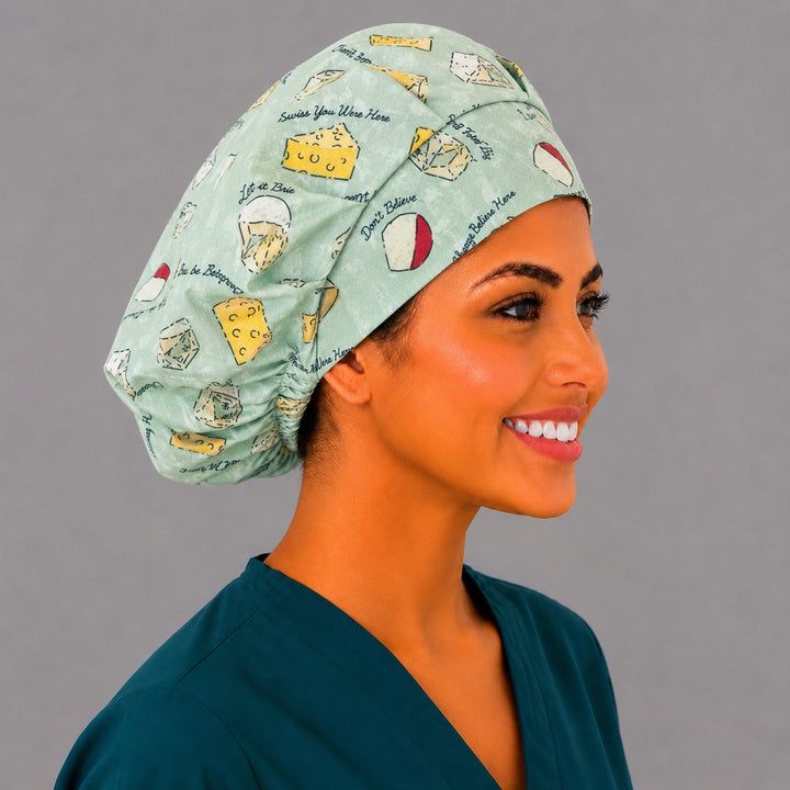 Side view of the Swiss You Were Here cheese bouffant surgical hat — brie, bleu and swiss wedges on sage, roomy cotton cap for nurses