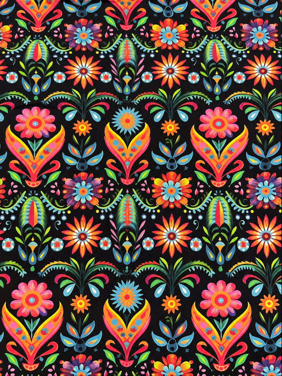Close-up of the symmetrical Mexican folk floral cotton fabric on black, with repeating pink flowers, turquoise sunbursts and green leaf fans