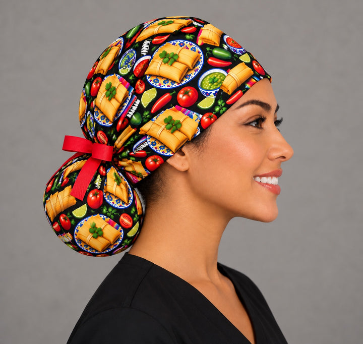 Side profile of a tamalada ponytail surgical hat, showing the full round bun pouch at the nape tied with a short red ribbon bow