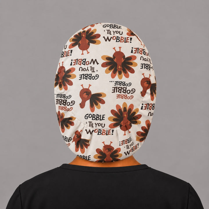 Back view of the Thanksgiving turkey Euro scrub cap — elastic gathered back showing turkeys and Gobble lettering across the cream crown