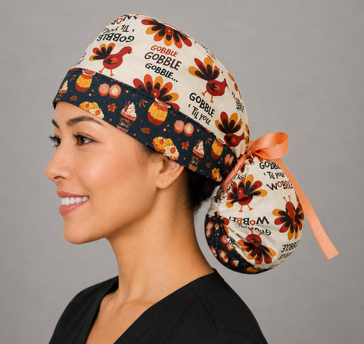 Thanksgiving turkey ponytail scrub cap left side profile showing gathered ponytail pouch of turkeys and Gobble Til You Wobble text with pumpkin-spice band and peach ribbon tie