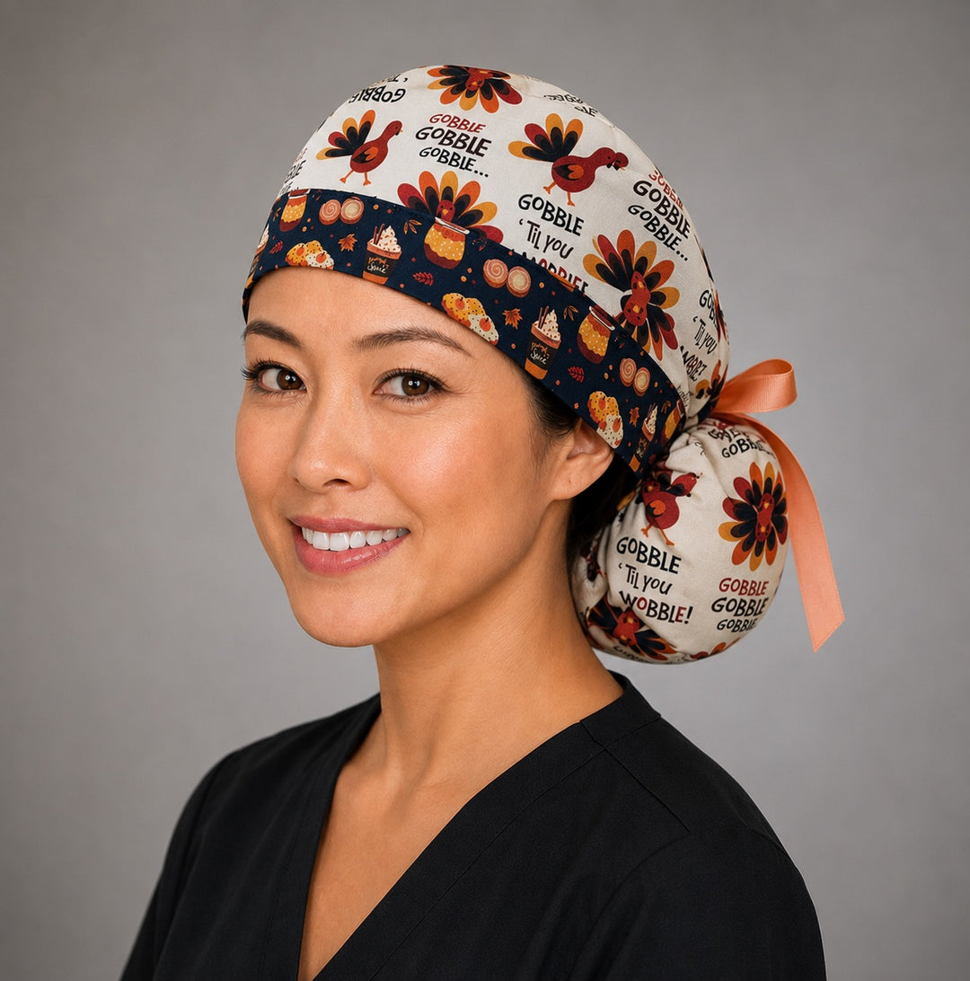 Thanksgiving turkey ponytail nurse cap left three-quarter angle showing turkeys and Gobble Til You Wobble text on cream with pumpkin-spice band and peach ribbon bow