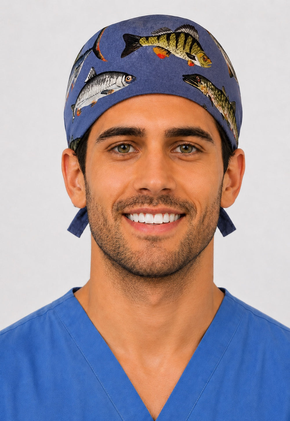 Traditional fishing fish print scrub cap, front view on smiling male healthcare worker — handmade unisex surgical hat with freshwater fish on blue, by OR World.