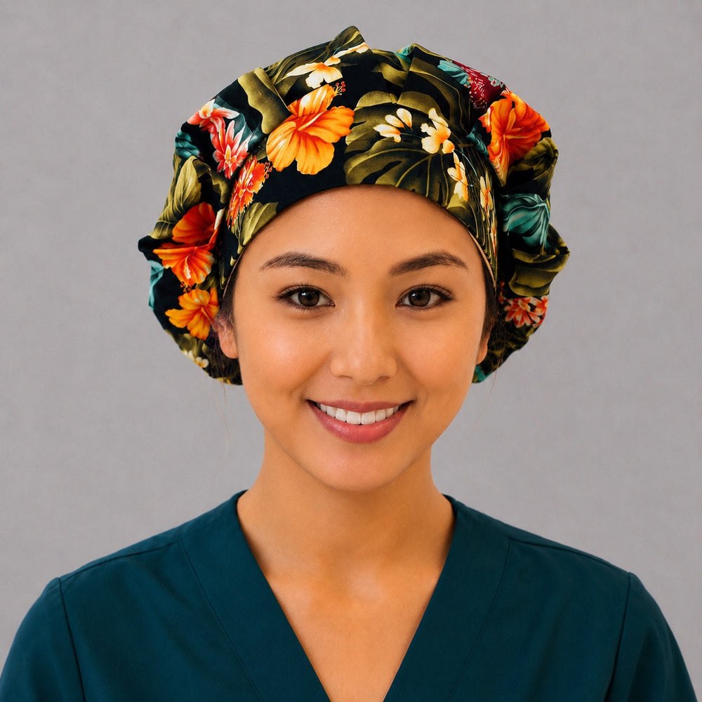 Tropical floral bouffant scrub cap front view on smiling model showing orange and red hibiscus on black tropical print, OR World nurse hat