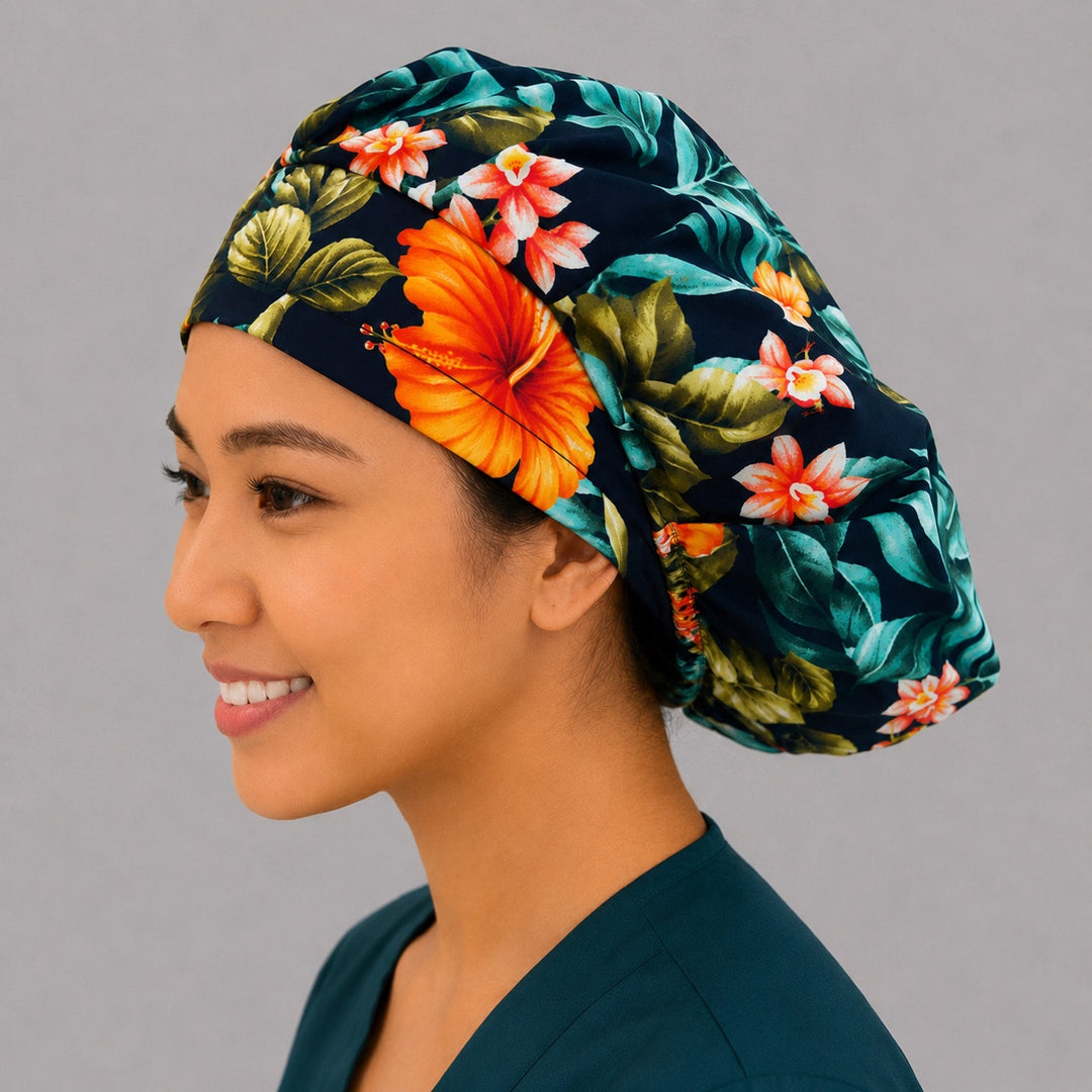 Tropical floral bouffant scrub cap left side profile showing orange hibiscus and monstera leaves on black, OR World tropical nurse hat