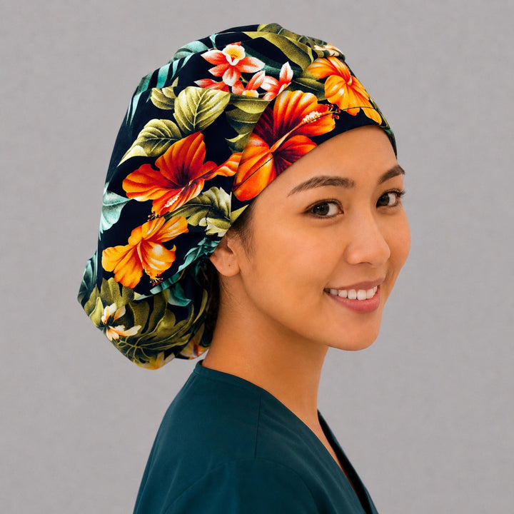 Tropical floral bouffant scrub cap right three-quarter angle showing orange and red hibiscus with green leaves on black, women&