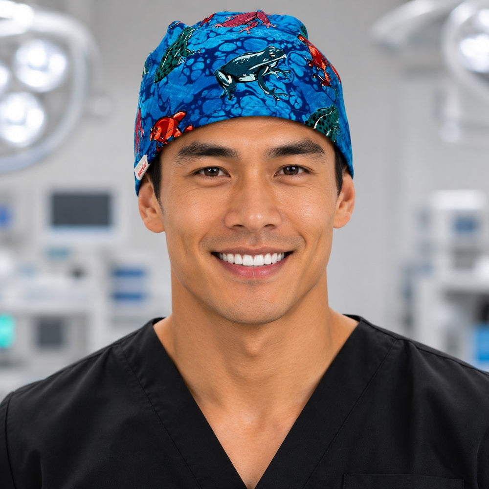 Tropical frogs scrub cap with red, teal and green poison dart frogs on blue, handmade men's tie-back surgical hat on male OR nurse, front view