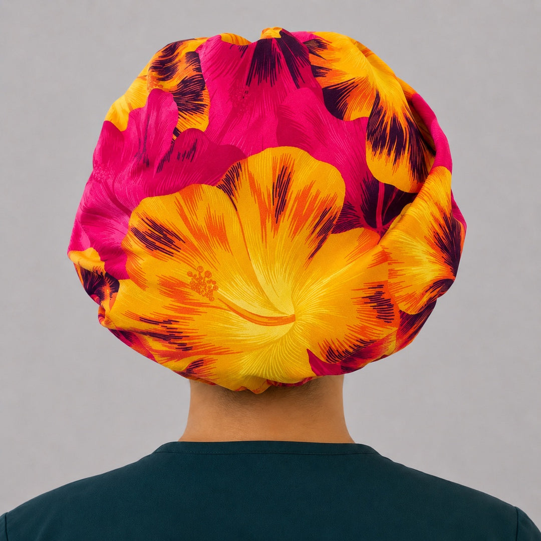 Tropical Hawaiian hibiscus bouffant surgical cap left side profile showing hot pink and orange hibiscus flowers, OR World tropical nurse hat