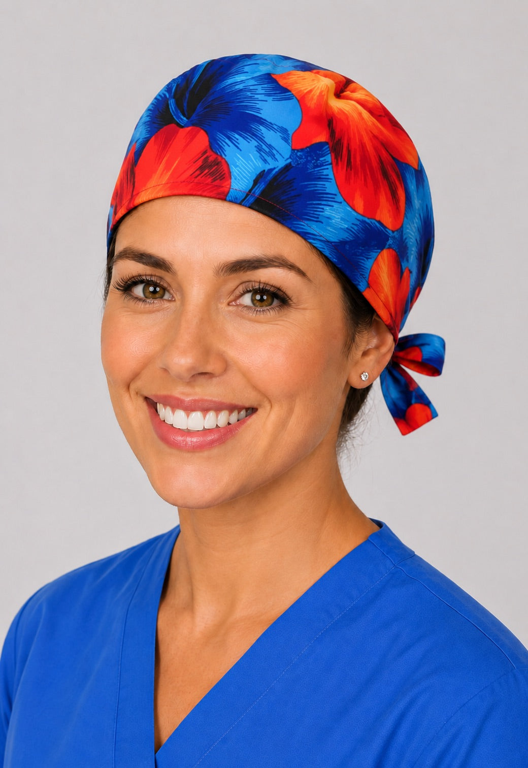 Three-quarter view of tropical hibiscus scrub cap in blue and orange, unisex adjustable surgical hat for nurses and surgical techs