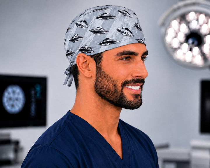 Side profile of man wearing UFO spaceships scrub cap in an operating room, grey print with flying saucers