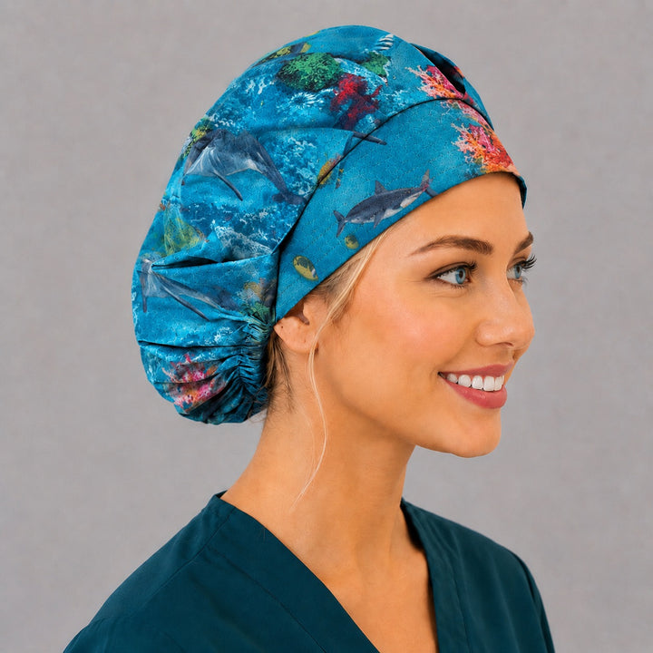 Side view of the underwater dolphin bouffant surgical cap — swimming dolphins, tropical fish and coral, roomy cotton cap for nurses