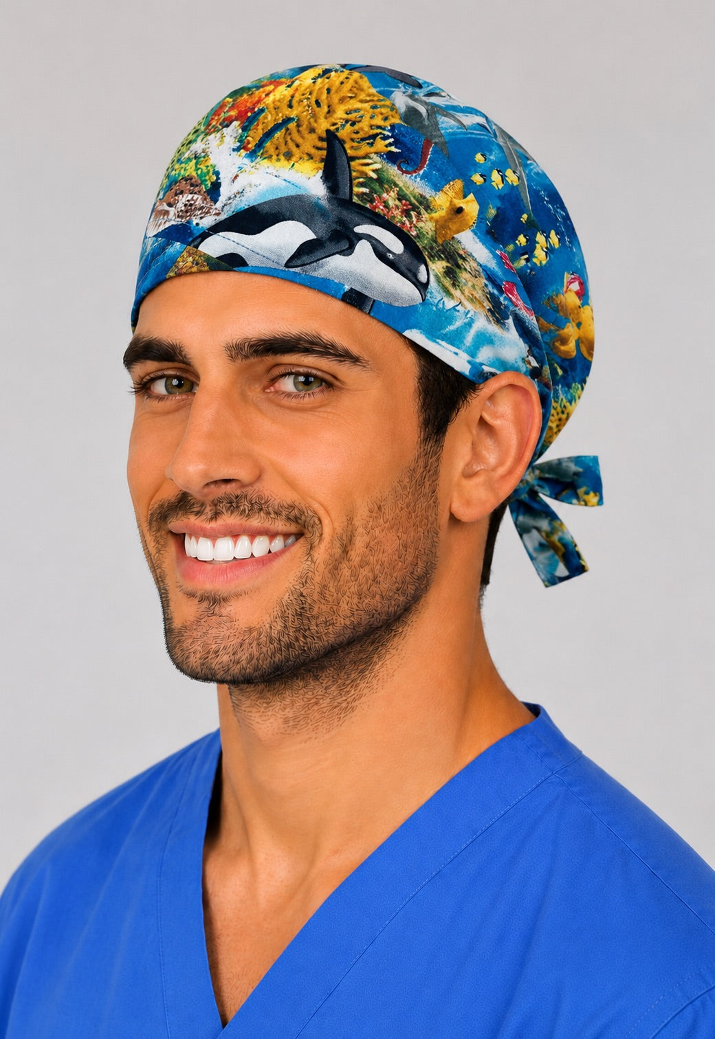 Side profile of Underwater Paradise ocean scrub cap on a male model, dolphin and tropical fish marine surgical hat for OR nurses and surgeons, handmade in USA by OR World.