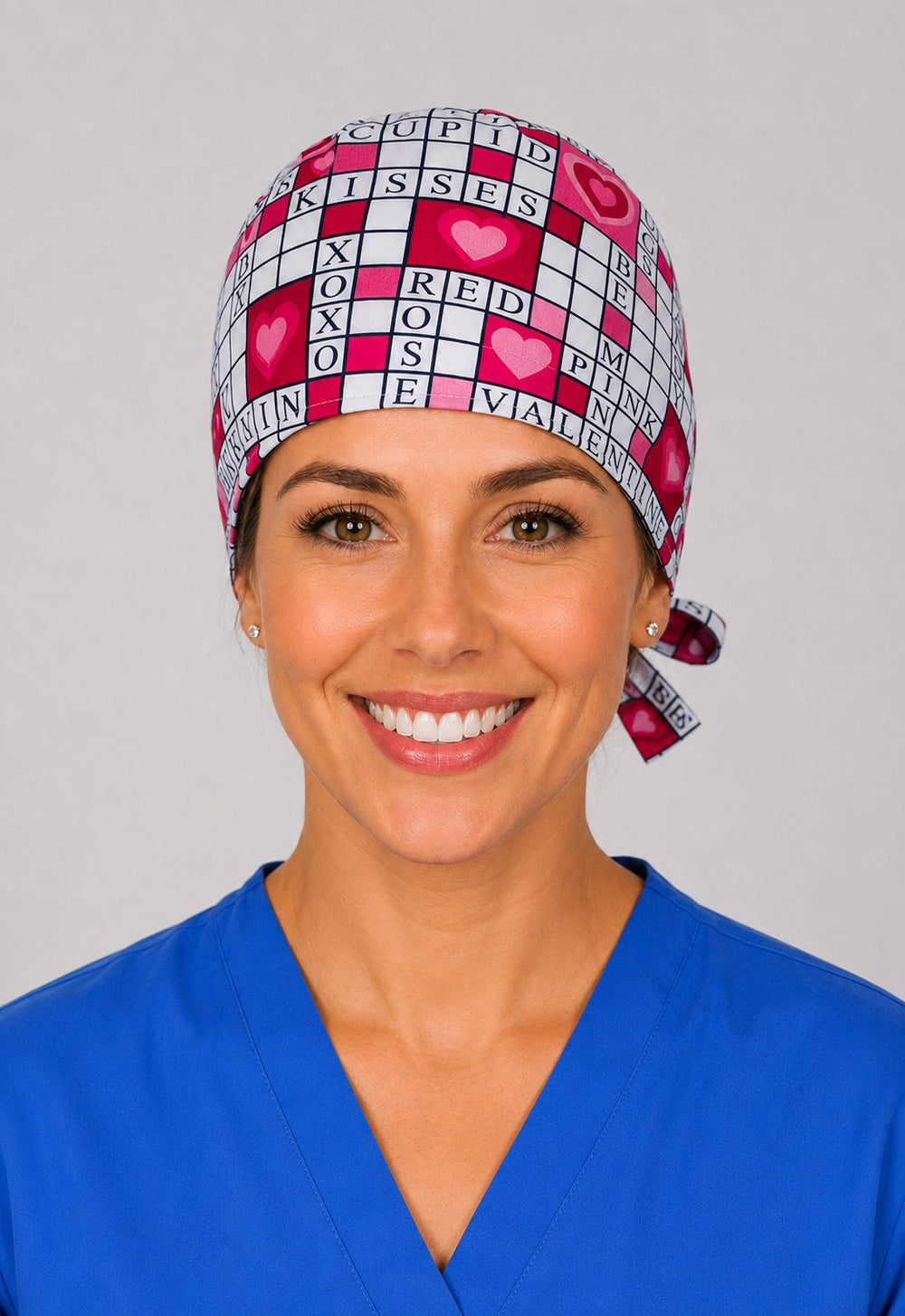 Valentine crossword puzzle scrub cap for short hair, handmade pink heart tie-back surgical hat on OR nurse, front view