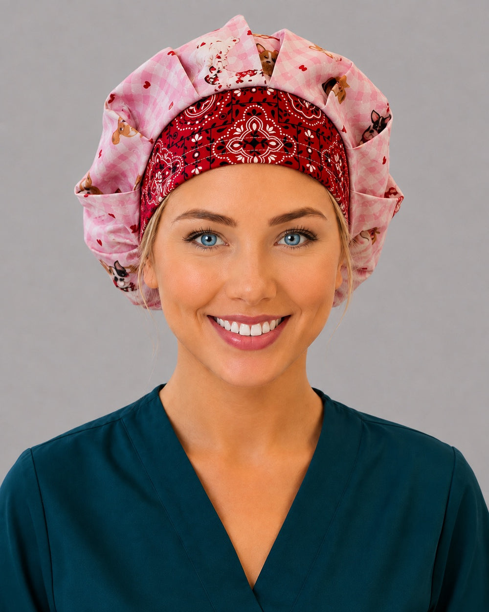 Woman wearing a Valentine dog bouffant scrub cap, front view — pink gingham puppy print with a red bandana band, adjustable women's surgical hat