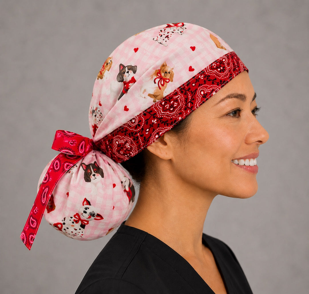 Valentine dogs ponytail scrub cap back view close-up showing gathered pouch full of puppies, hearts and bows on pink gingham with red bandana ribbon bow