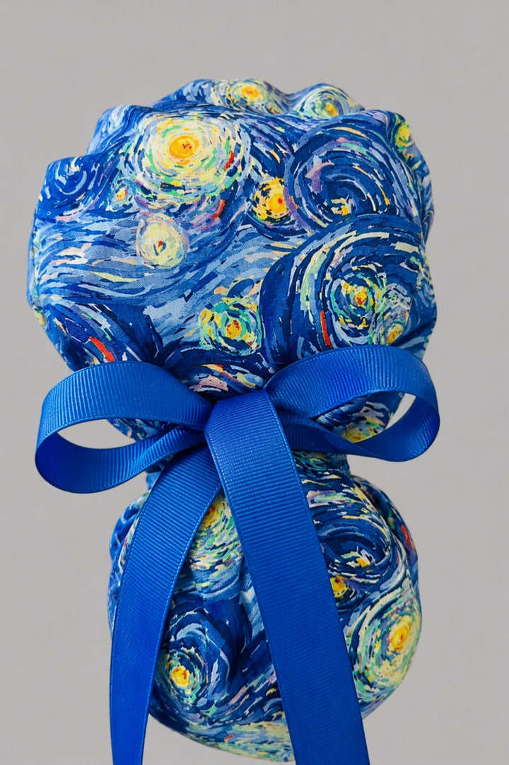 Van Gogh Starry Night ponytail scrub cap back view close-up showing gathered pouch full of swirling blue, turquoise and gold impressionist starry print with blue ribbon bow