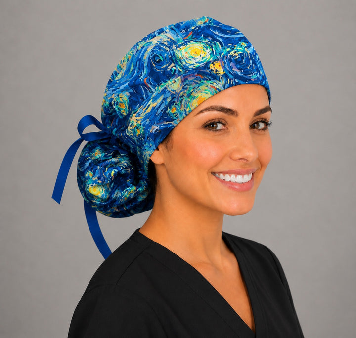 Van Gogh Starry Night ponytail scrub cap left front angle on smiling model showing swirling blue, turquoise and gold impressionist starry print with blue ribbon bow
