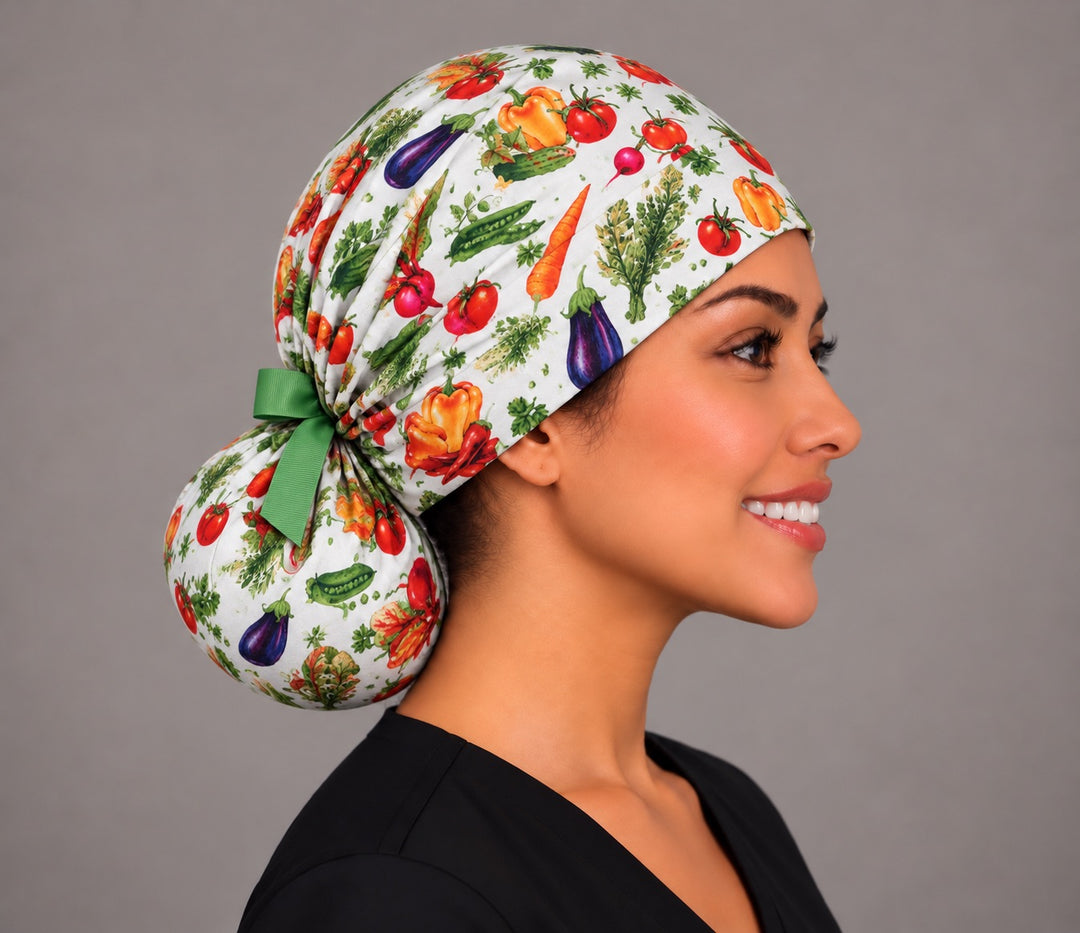 Side profile of a vegetable print ponytail surgical hat, showing the full round bun pouch at the nape holding long hair