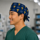 Side view of navy gold-trophy "Voted #1 Surgeon" tie-back scrub cap on a male model — handmade USA surgical hat, gift for surgeons.