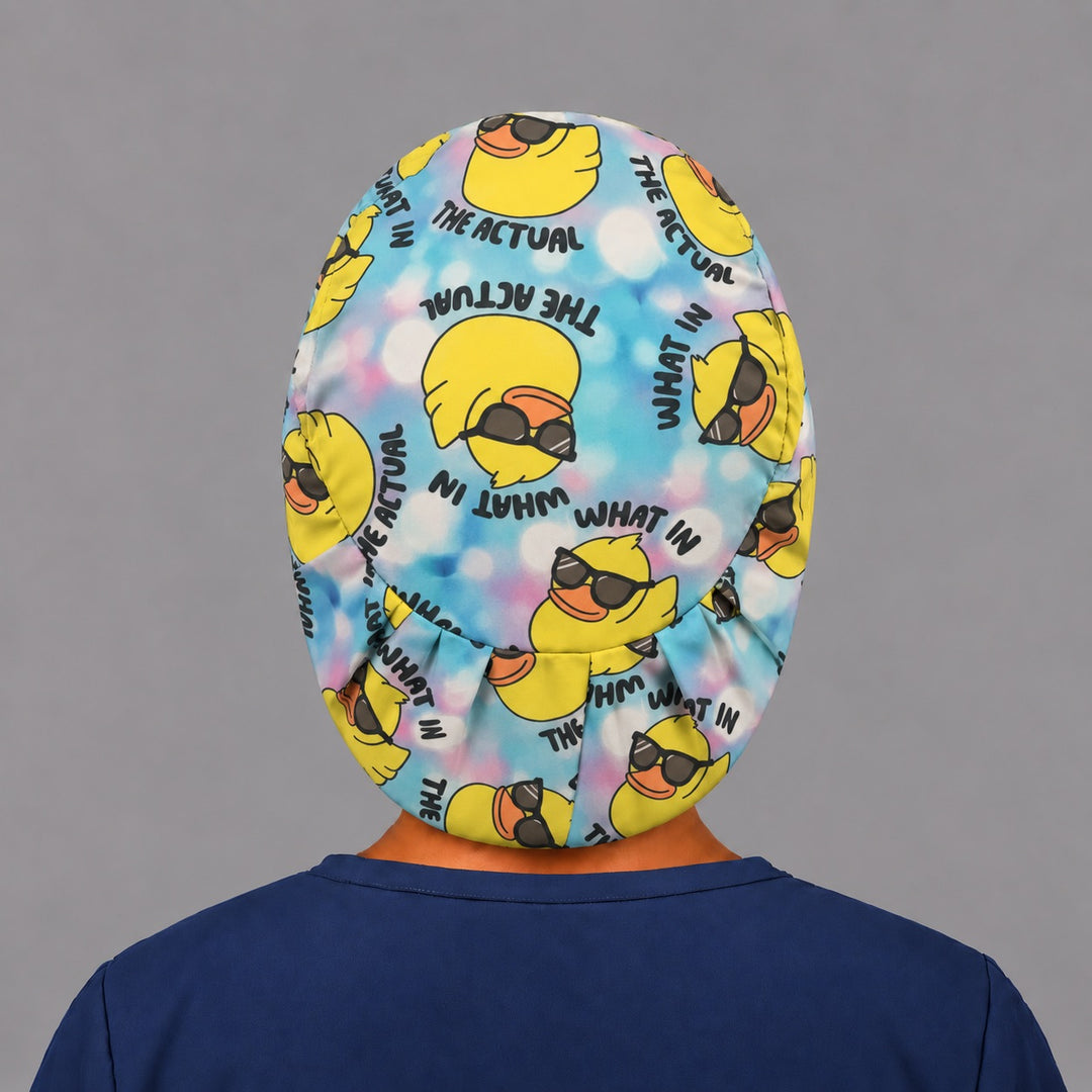 Back view of the What in the Actual Duck Euro scrub cap — elastic gathered back showing ducks across the tie-dye crown