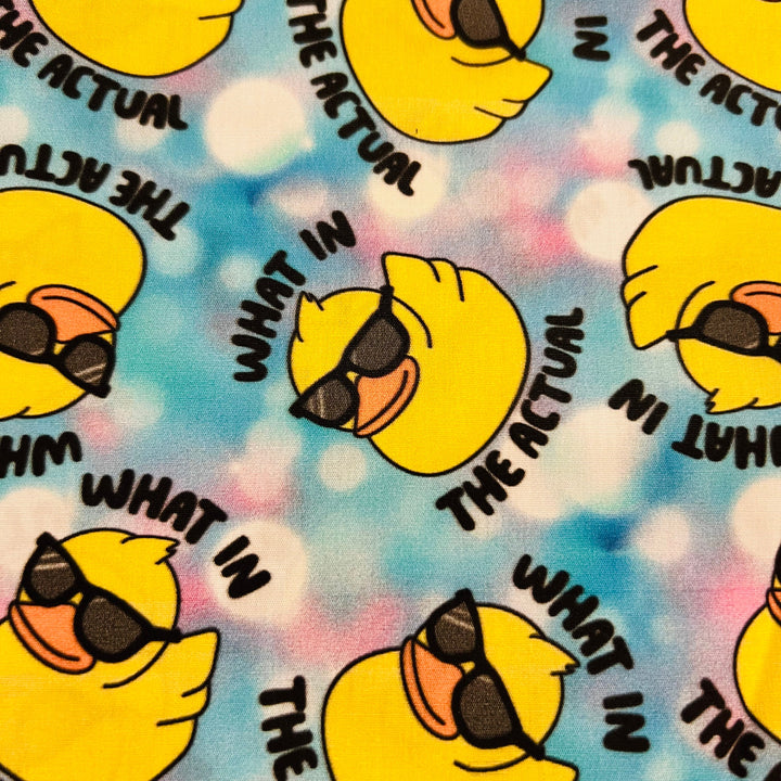 What in the Actual funny duck scrub cap fabric close-up — rubber ducks in sunglasses on blue tie-dye cotton print for nurse surgical caps