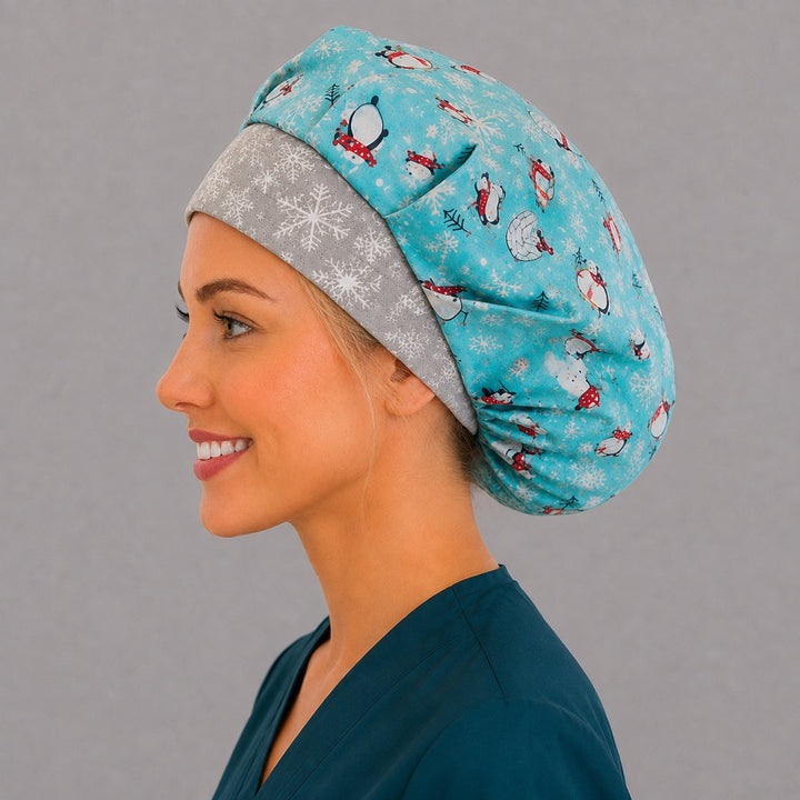 Back view of the winter penguin bouffant scrub cap — penguins, igloos, hot chocolate and snowflakes across the full aqua crown