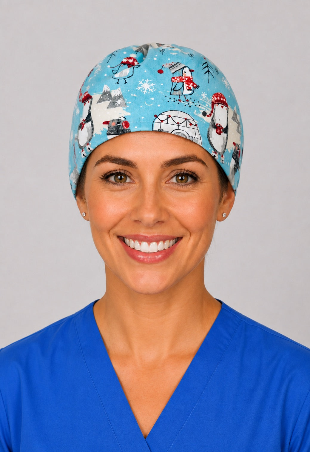 Winter penguin scrub cap for short hair, handmade aqua tie-back surgical hat with penguins and igloos on OR nurse, front view