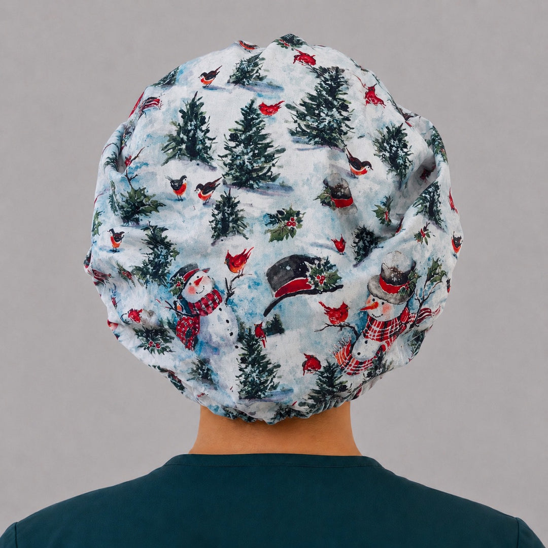 Woman wearing a winter snowman bouffant scrub cap, front view — snowmen, cardinals and pines with red buffalo plaid band, adjustable women&