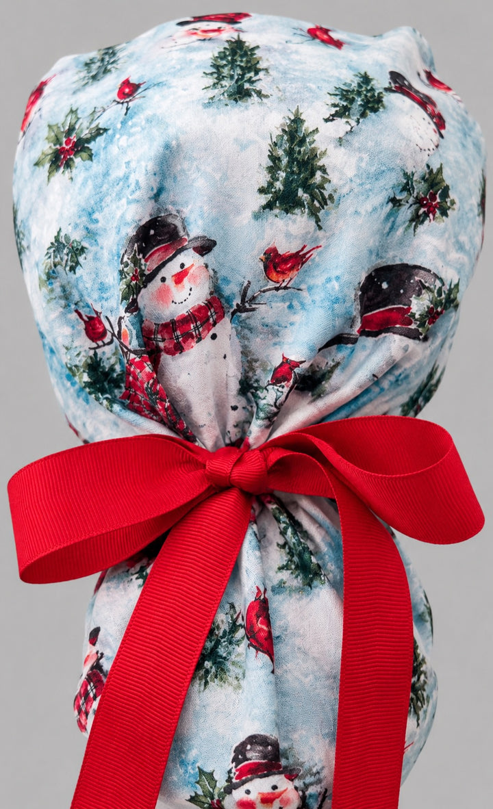 Winter snowman ponytail scrub cap right side profile with full ponytail pouch of snowmen, cardinals and holly and long red ribbon ties