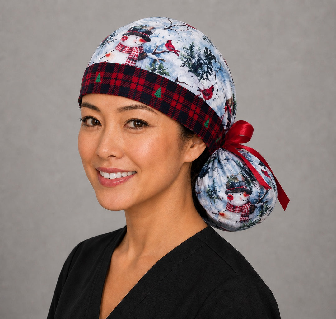 Winter snowman ponytail nurse cap right three-quarter angle on smiling model showing snowmen, red cardinals and red plaid band with red ribbon bow