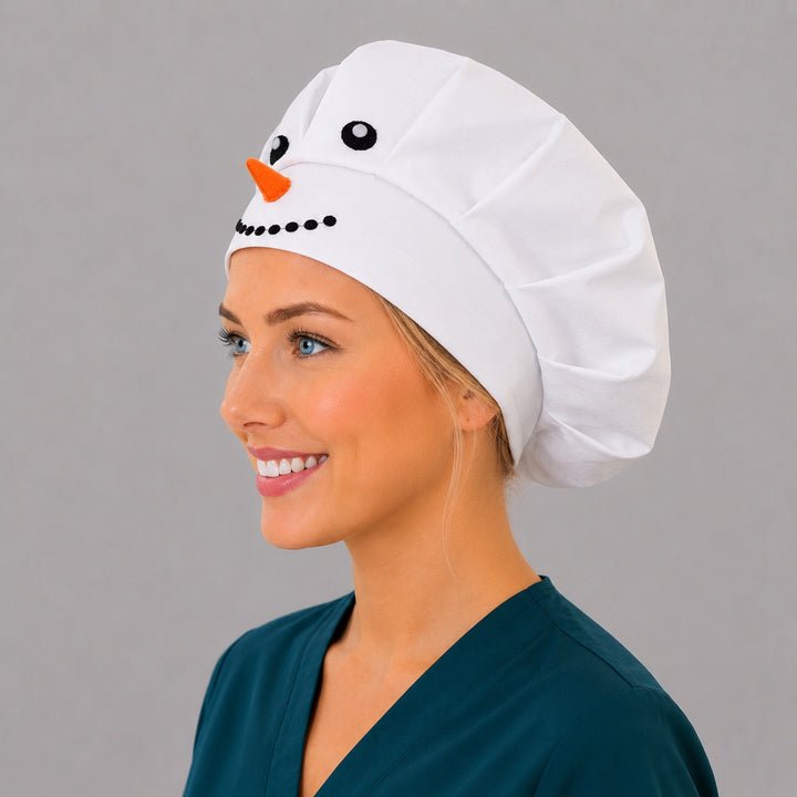 Winter white snowman bouffant scrub cap left three-quarter angle on smiling model showing 3D snowman face and orange carrot nose, women&