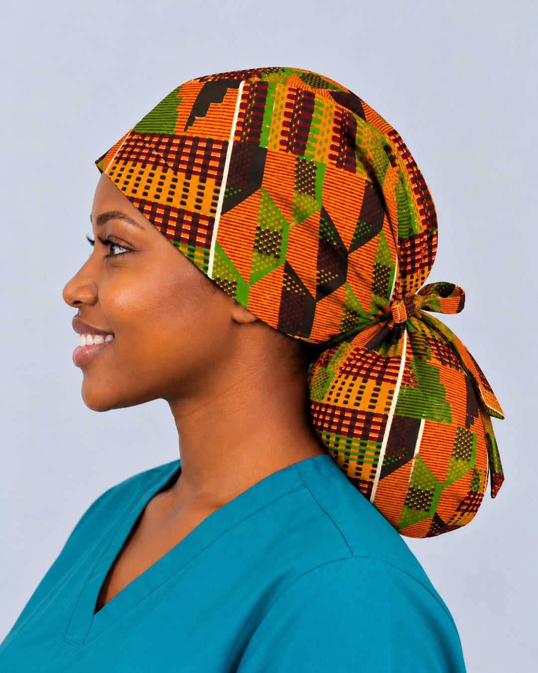 Left side profile of an XL Kente nurse hat for locs, with a thin white stripe running from the brim down into the deep rounded ponytail pouch