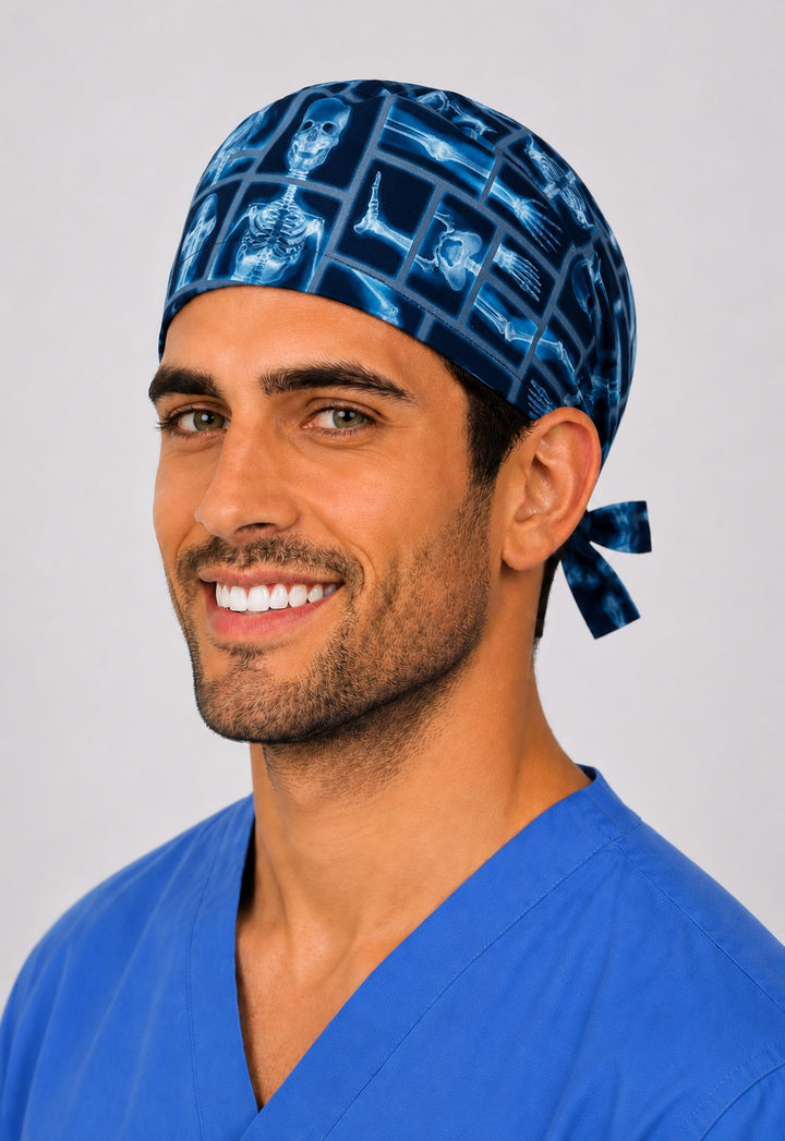 Blue x-ray bone print surgical hat on smiling male radiographer, angled view — radiology tech tie-back scrub cap by OR World.