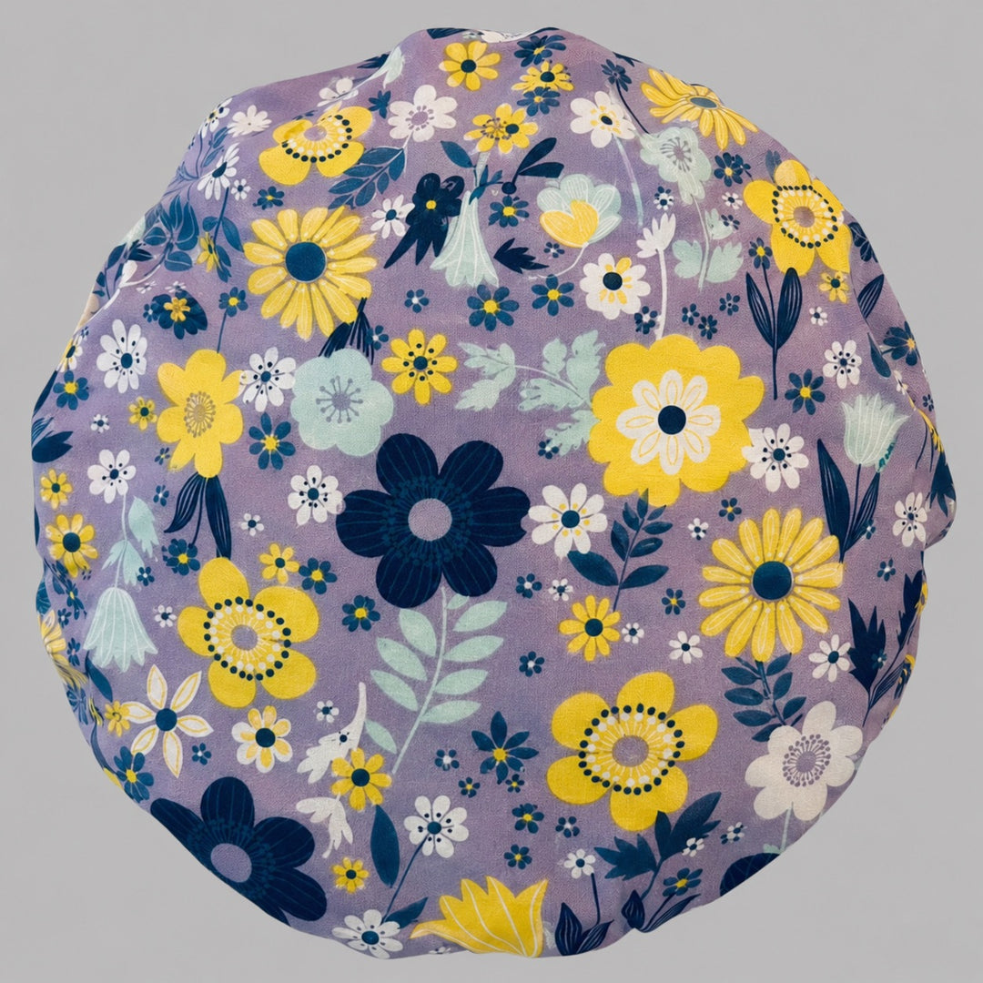 Top-down detail of the yellow and white floral bouffant scrub cap — close-up of the lavender purple floral print on soft cotton